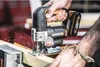 A person is using a cordless jigsaw to cut wood, with sparks flying. Podgląd zdjęcia produktu