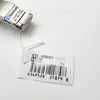 A watch tag with product information and a barcode is shown next to a part of a silver watch with a Bluetooth logo. Produktbild-Vorschau