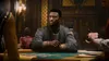 A man sits at a casino table, looking off to the side. Another person's hand is visible holding cards. Produktbild-Vorschau