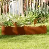 A rusted metal garden border with fairy silhouettes is placed on a green lawn in front of a wooden fence and garden plants. Produktbild-Vorschau