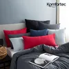 A bed with multiple pillows and a book. Produktbild-Vorschau