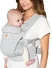 A woman is wearing a baby carrier with a baby in it. Produktbild-Vorschau