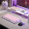 A pink mechanical gaming keyboard and mouse are set up on a desk with a monitor and other gaming accessories. Produktbild-Vorschau