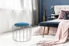 A bedroom scene with a pouf in the foreground and a bed in the background. Produktbild-Vorschau