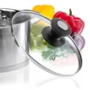 A close-up of a pot lid with vegetables in the background. Anteprima dell’immagine prodotto