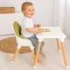 A young child is sitting at a small white table and eating. Náhľad obrázku produktu