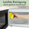 A hand is cleaning the inside of a microwave with a yellow sponge. Produktbild-Vorschau