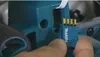 A close-up shot of a hand holding a small electronic component with the Makita logo on it, about to insert it into a teal-colored power tool. Anteprima dell’immagine prodotto