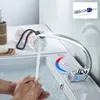 Hands being washed under a modern chrome faucet in a bathroom sink. Produktbild-Vorschau