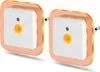 Two white square LED night lights with orange glowing borders, plugged into an unseen outlet. Produktbild-Vorschau