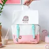 A Pusheen backpack is displayed on a wooden surface, with a drink and other items nearby. Anteprima dell’immagine prodotto