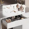 A close-up view of an open drawer of a white vanity table, filled with makeup and accessories. Voir les images du produit