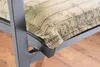 A close-up view of a chair cushion with a wood-grain and camouflage pattern, resting on a dark metal chair frame. The background shows a wooden floor. Produktbild-Vorschau