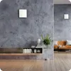 A modern living room with a wall-mounted ventilation unit and a shelf with books and decor. Náhled obrázku produktu