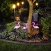 A garden scene at night with solar-powered flamingo lights. Podgląd zdjęcia produktu