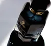 A close-up shot of a black perfume bottle with a gold accent and a label. Voir les images du produit