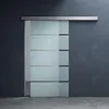 A frosted glass sliding door with horizontal frosted stripes and black accents, mounted on a dark gray wall. Produktbild-Vorschau