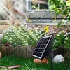 A solar-powered drip irrigation system is shown in a garden setting, with a person sitting in the background. Produktbild-Vorschau