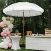 An outdoor party setup with a white fringed umbrella, balloon arch, and dessert table. Produktbild-Vorschau