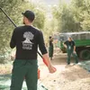 People harvesting olives in an orchard with a truck in the background. Produktbild-Vorschau