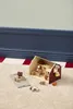 A wooden toy barn and farm animals are arranged on a textured carpet, with a blue and white striped baseboard in the background. Produktbild-Vorschau