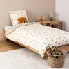A child's bed with leopard-themed bedding, a stuffed animal, and a small bedside table with a lamp. Podgląd zdjęcia produktu
