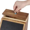 A hand is shown inserting a key into a lock on a wooden suggestion box. Náhled obrázku produktu
