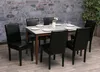 A dining table set with chairs in a room with a stone wall. Náhľad obrázku produktu