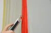 A hand is using a utility knife to cut a red zipper. Produktbild-Vorschau