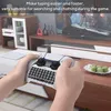 A person is holding a white controller with a keyboard attachment in front of a television. Produktbild-Vorschau
