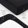 A close-up view of a black fitted sheet, highlighting its elastic edge and features. Produktbild-Vorschau