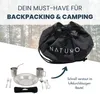 A camping set with cutlery, plates, and cups is displayed next to a drawstring bag, with a forest background. Produktbild-Vorschau