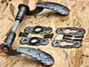 A set of rustic door handles and escutcheons with screws, laid out on a wooden surface. Produktbild-Vorschau