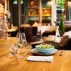 A table setting in a restaurant with a salad, wine, and water. Produktbild-Vorschau