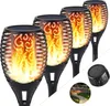 A group of solar-powered garden lights with a flame effect, shown against a white background. A small inset image shows the lights installed in a garden setting. Produktbild-Vorschau