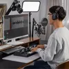 A person is using a computer and audio equipment in a home studio setup. Podgląd zdjęcia produktu