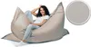 A woman is sitting comfortably in a large, beige beanbag chair. A close-up of the fabric texture is shown in a circular inset. Produktbild-Vorschau