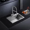 A modern kitchen sink and faucet setup on a black marble countertop. Podgląd zdjęcia produktu