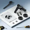 A collection of plumbing fixtures and tools laid out on a marble surface. Produktbild-Vorschau