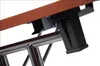 A close-up view of the underside of a wooden tabletop supported by a black metal frame with chrome legs. Produktbild-Vorschau