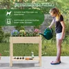 A young girl waters a raised garden bed filled with colorful flowers. The garden bed is made of wood and has a shelf underneath. The background shows a garden setting with greenery and a stone wall. Text overlays highlight product features. Podgląd zdjęcia produktu