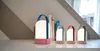 Four LED lanterns of varying sizes are displayed on a shelf with books in the background. Produktbild-Vorschau
