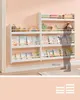 A child's bedroom with white bookshelves filled with books and toys against a pink wall. A silhouette of a child is shown next to the shelves for scale. Náhled obrázku produktu