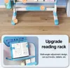 A close-up view of a blue and white children's study desk with a reading rack and some text overlays highlighting its features. Produktbild-Vorschau