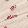 A close-up view of a fabric with a floral pattern. Produktbild-Vorschau