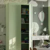A brightly lit children's room with an open light green wardrobe displaying folded clothes and toys. Náhľad obrázku produktu