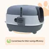 A gray and white cat litter box with a scoop attached, shown from a side-angle. A graphic of a paw print is visible in the background. Náhled obrázku produktu