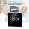 An elderly couple is smiling and looking at the camera, with a thermostat prominently displayed in the foreground. Produktbild-Vorschau