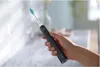 A hand holding an electric toothbrush. Anteprima dell’immagine prodotto
