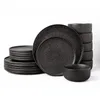 A set of black ceramic plates and bowls stacked against a white background. Náhľad obrázku produktu